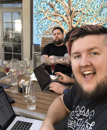 calvin taking a selfie in front of his computer with Arlton napping in the background